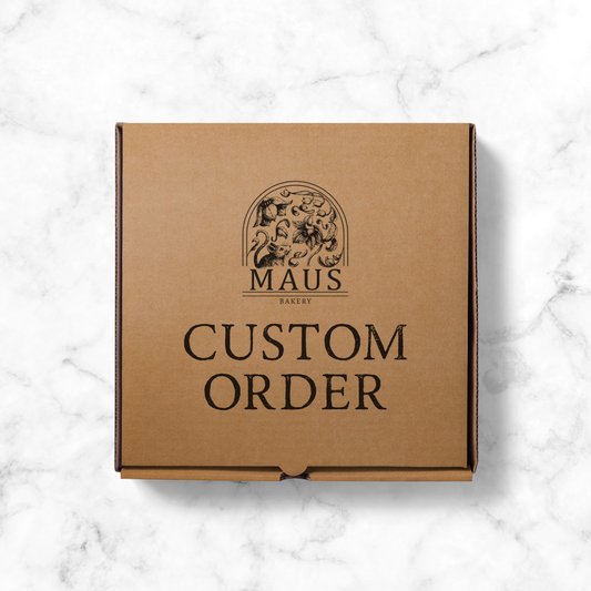 Brown cardboard box with 'MAUS Bakery' logo and 'Custom Order' text on a marble surface